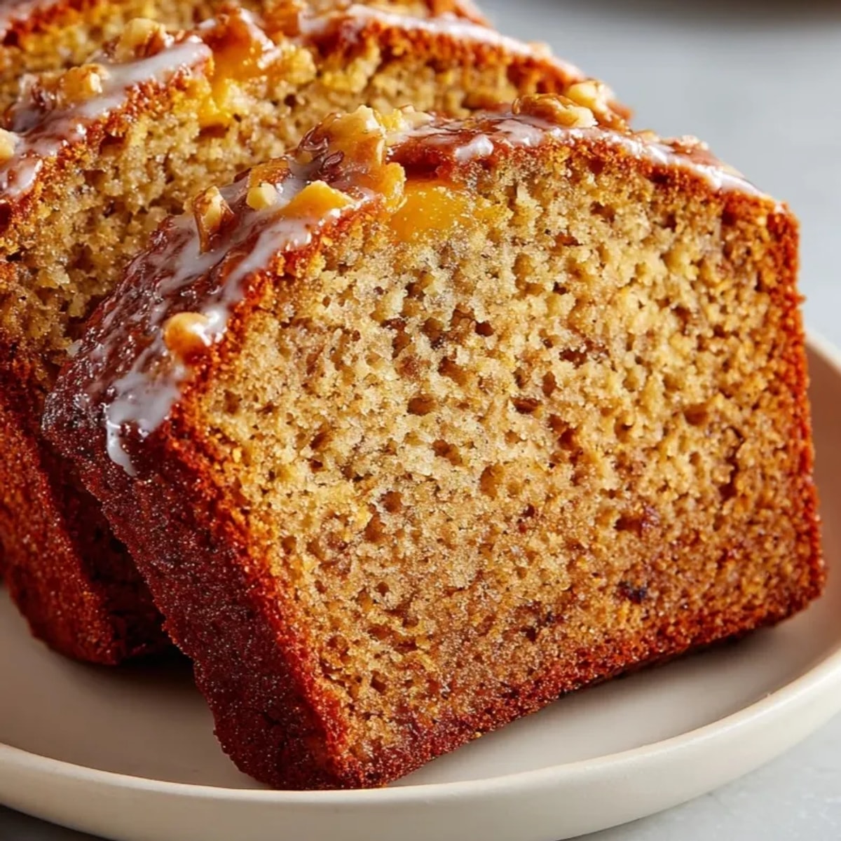 Moist pumpkin spice banana bread slice showing warm spices, ready to eat.