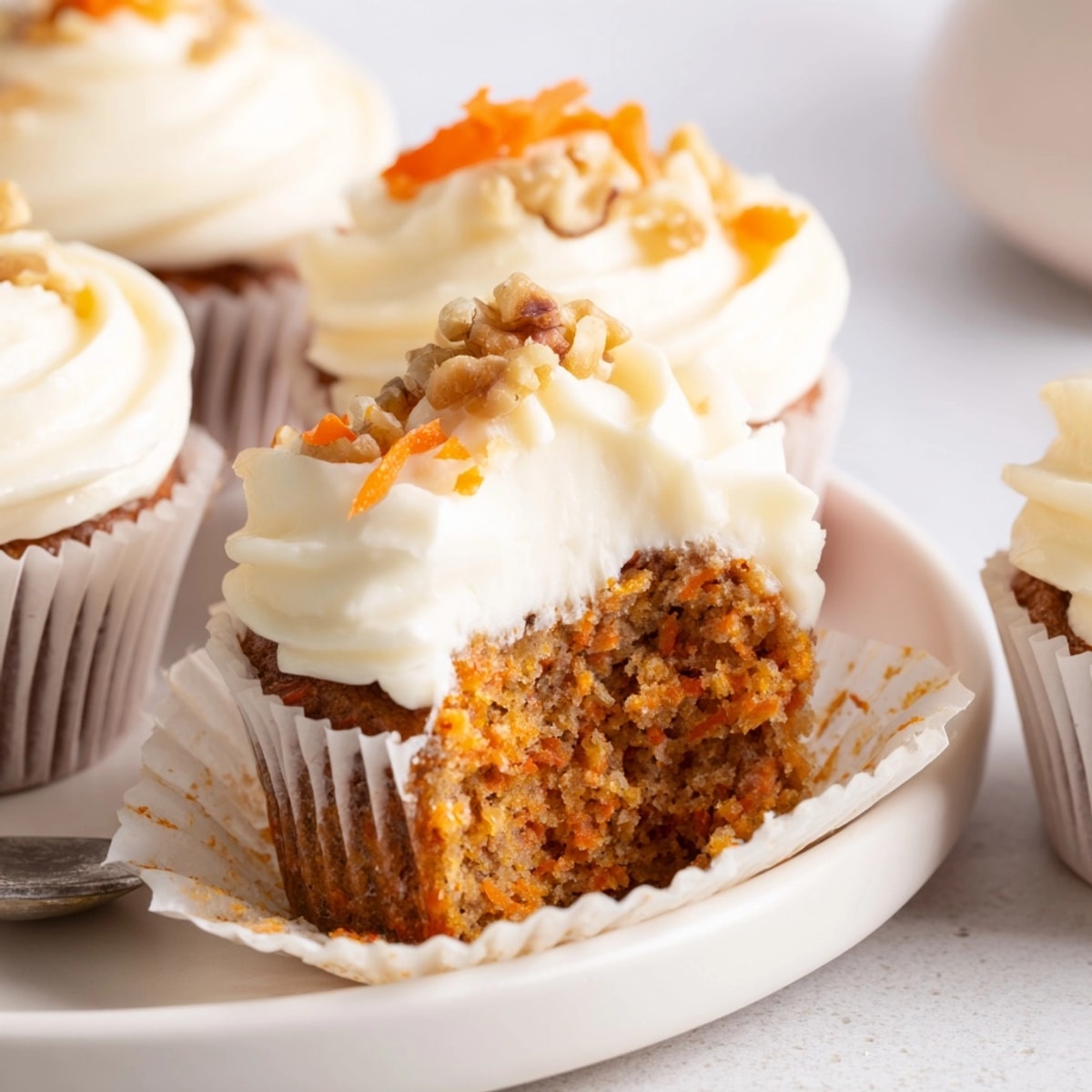 Homemade Carrot Cake Cupcakes, presented on a plate; view the moist, spiced crumb.