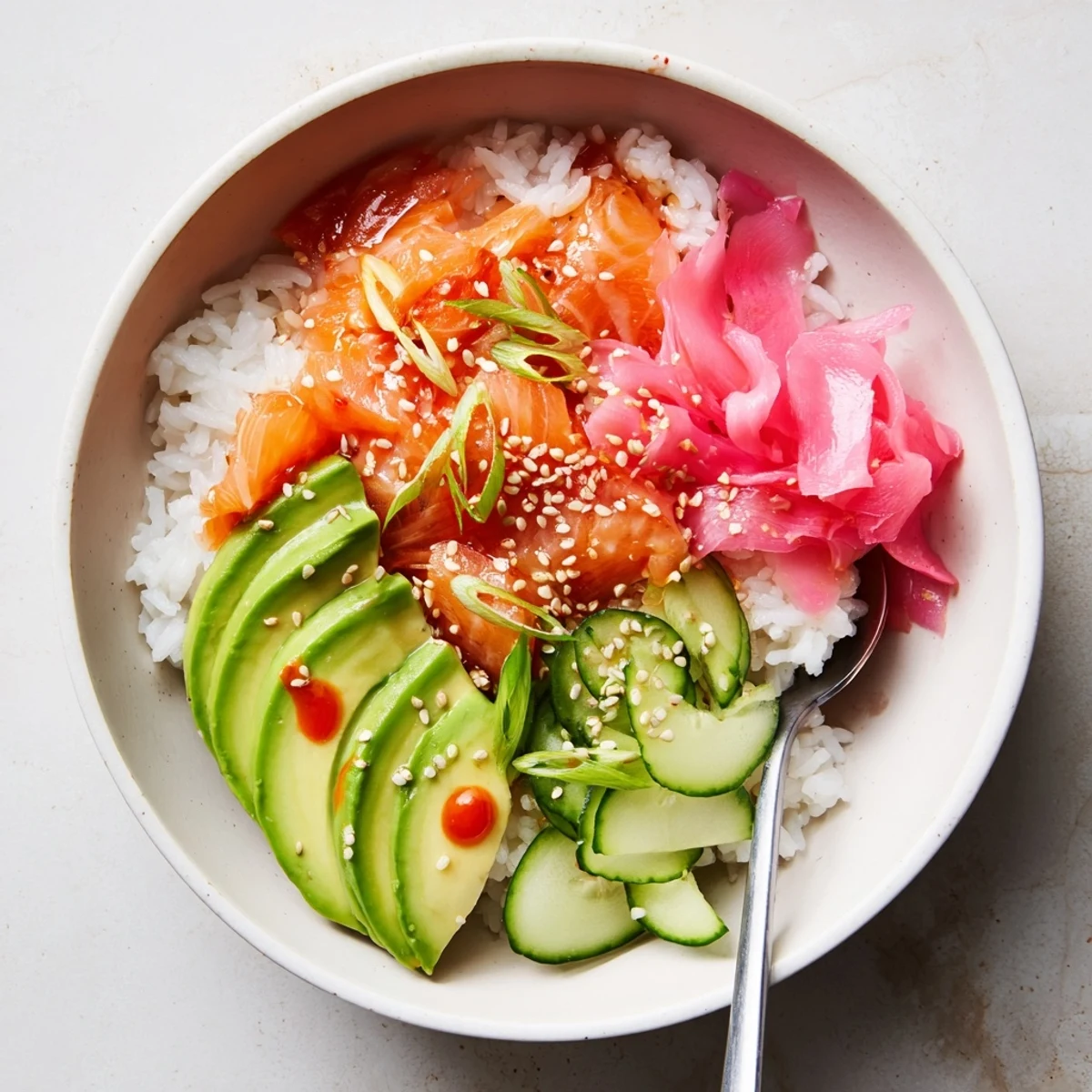 Flavorful leftover salmon and rice bowl topped with fresh avocado and cucumber.  