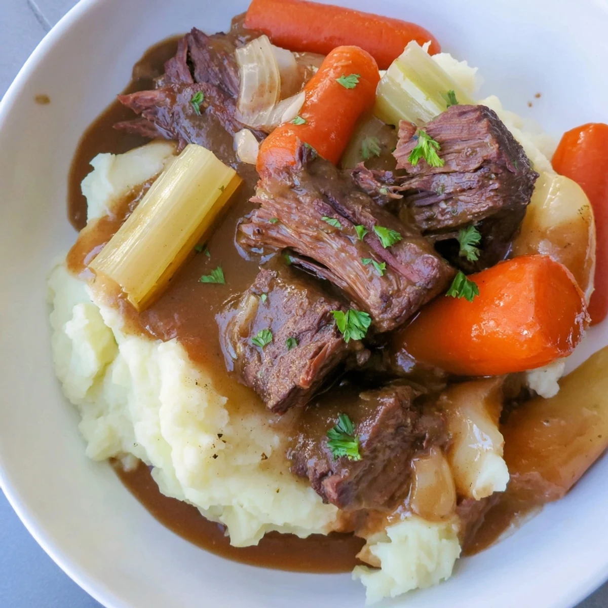 Hearty Slow Cooker Pot Roast recipe, featuring fork-tender beef and a flavorful gravy with mashed sides.