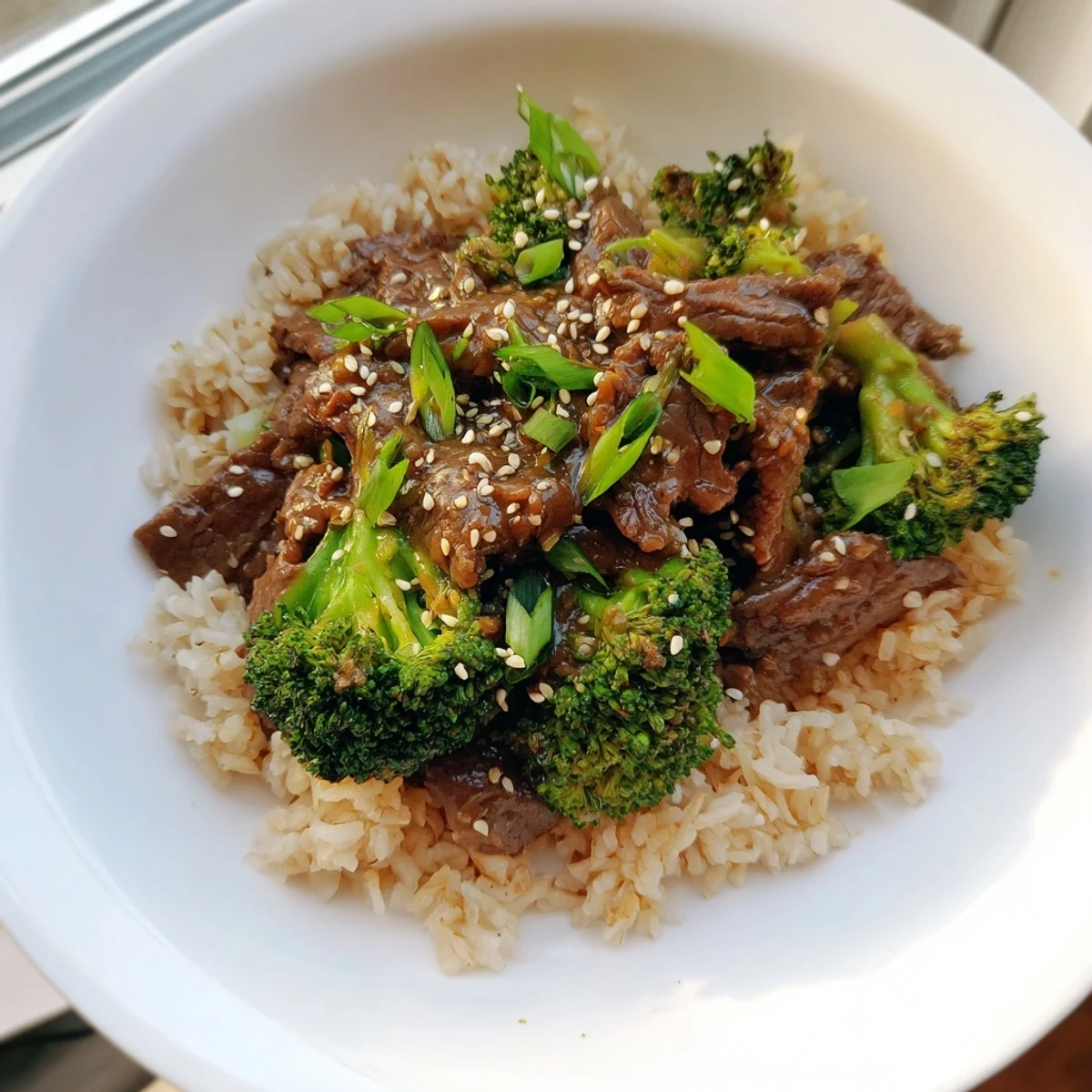 A warm bowl of flavorful Slow-Cooker Beef & Broccoli, with vibrant green broccoli and rice.