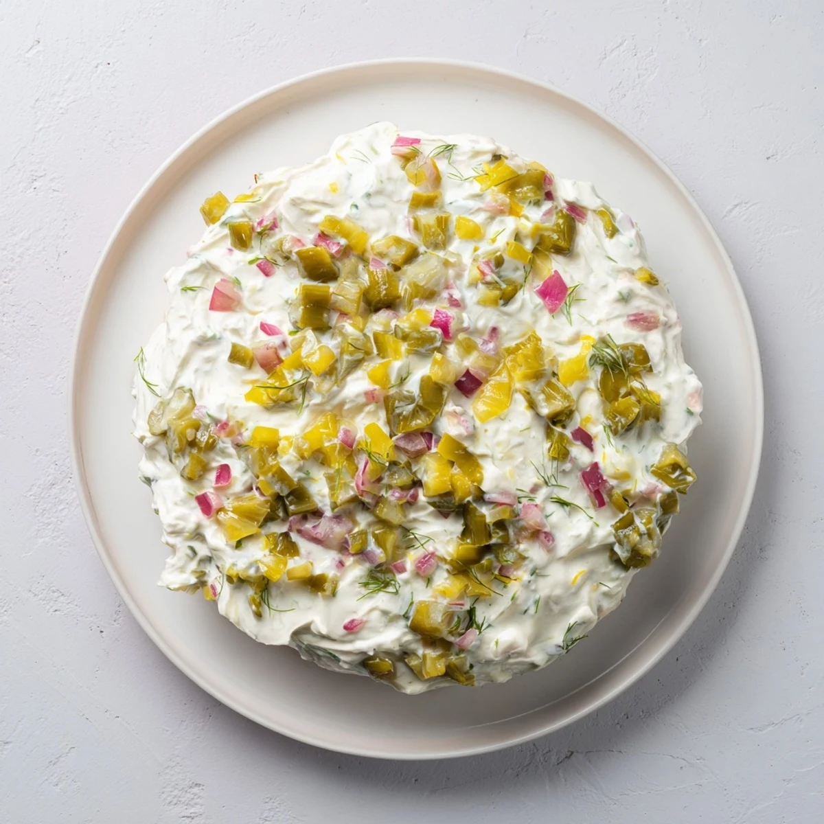 Creamy Sweet and Sour Pickle Relish Dip served with a pile of crispy potato chips for dipping.