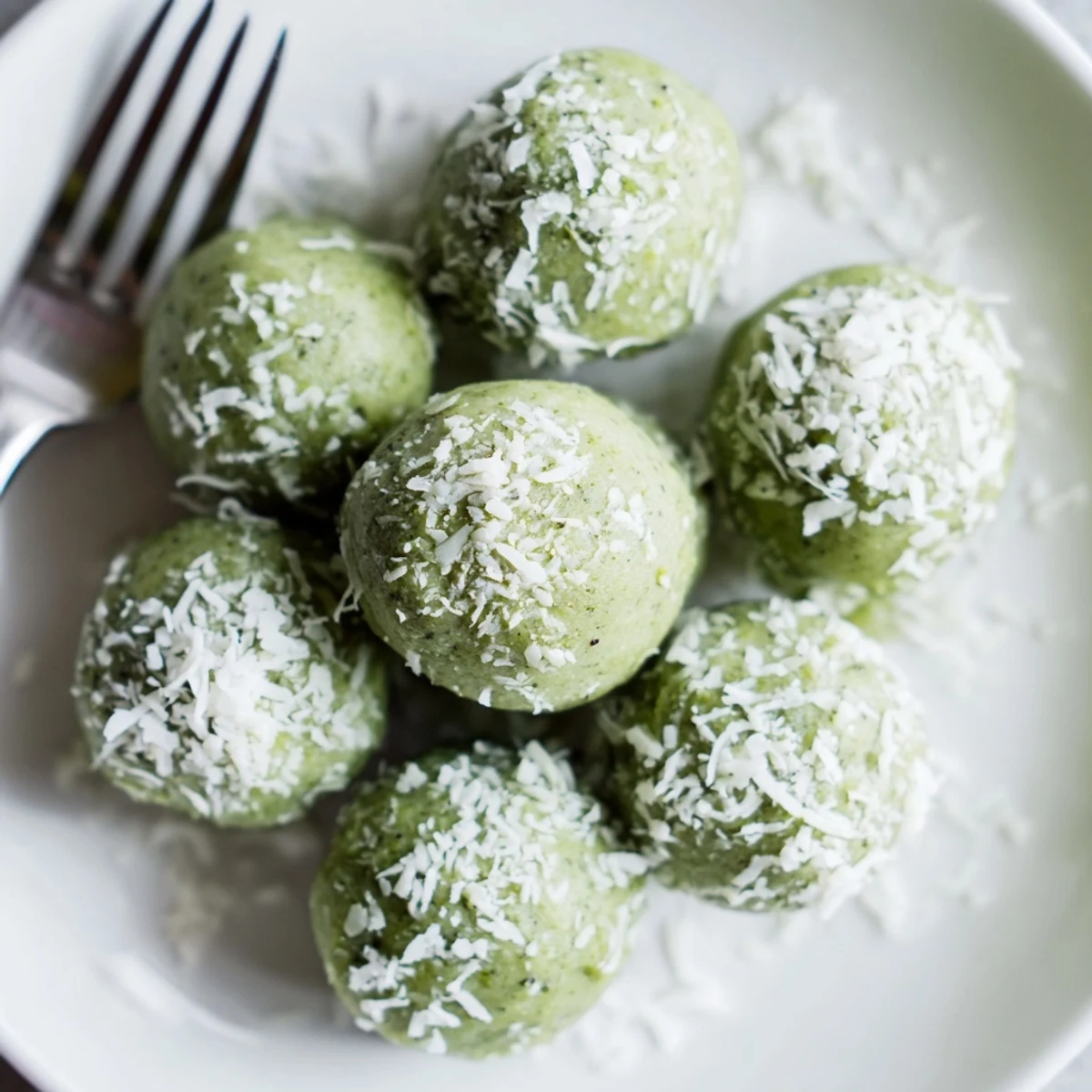 Close-up of chilled Coconut Matcha Snowball Fat Bombs, offering a delightful blend of matcha and coconut flavor.