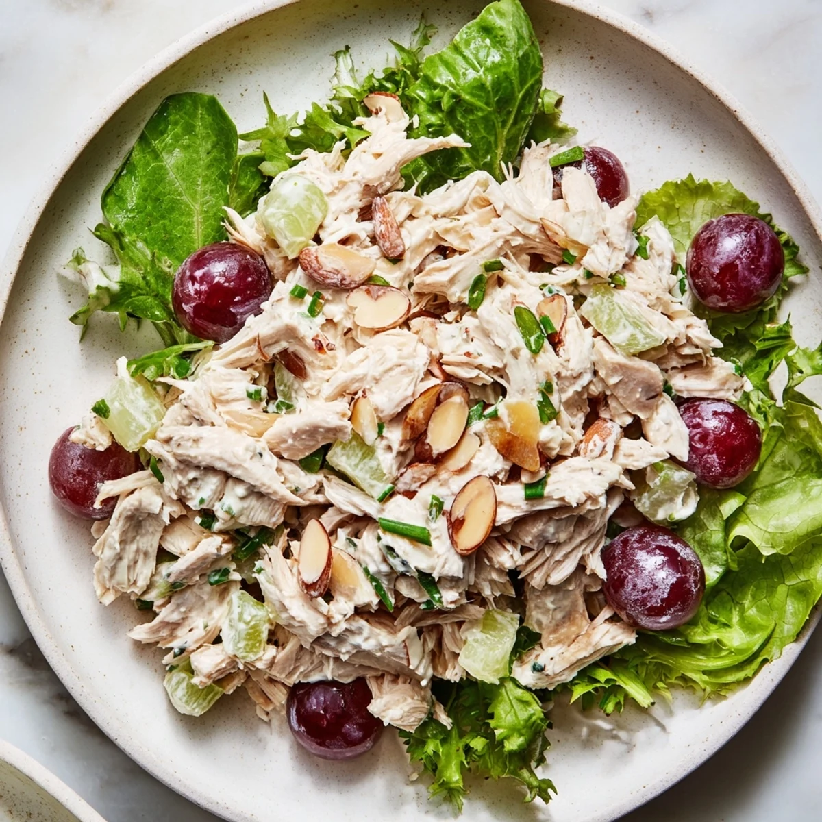 Creamy Crispy Chicken Salad with juicy grapes atop fresh greens, a light, flavorful lunch.
