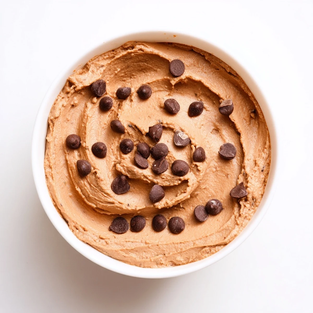 This creamy vegan chocolate hummus with a swirl of almond butter offers a sweet, satisfying snack.