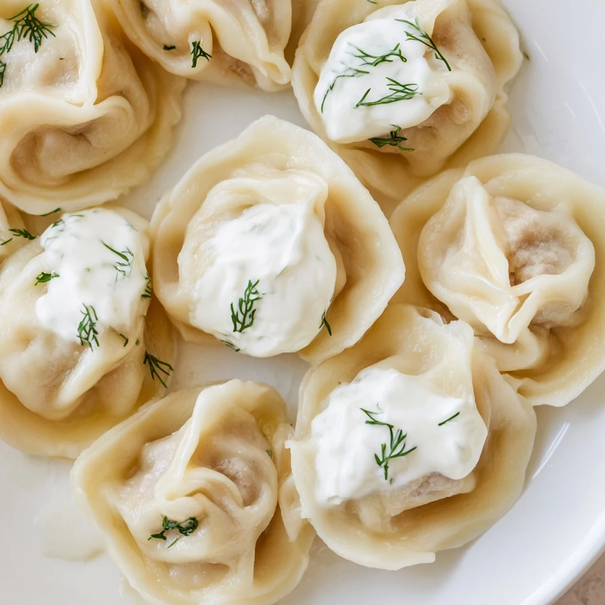 A close-up of golden Russian pelmeni, ready to eat, swimming in flavorful broth.