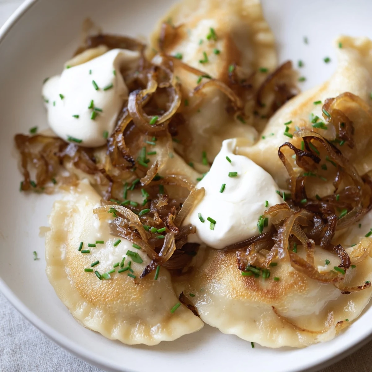 Golden, pan-fried Polish pierogi dumplings sit with sweet onions, ready for a delicious dinner.