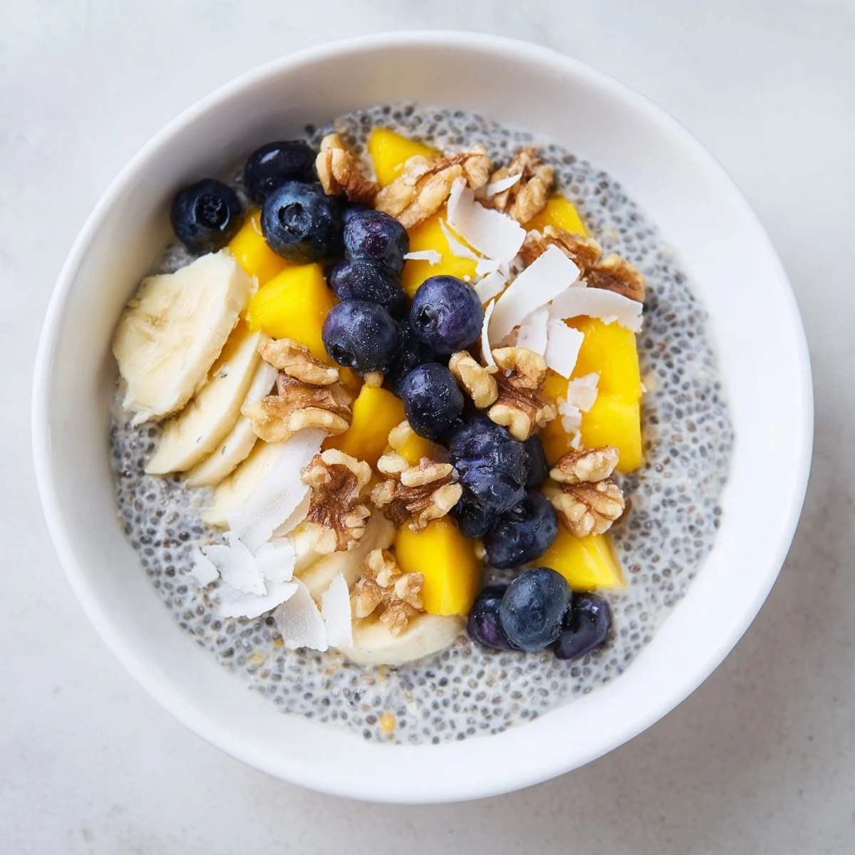 Overnight chia seed pudding, layered in a glass with colorful fruits, perfect breakfast.