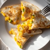 Deliciously browned Cheesy Mango Quesadilla being sliced; savor the contrast of sweet and savory.