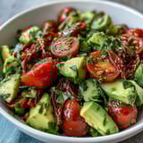 Colorful cucumber tomato avocado salad with zesty lemon dressing, a refreshing and easy vegan side dish for summer gatherings.