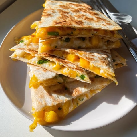 Golden, crisp Cheesy Mango Quesadilla triangles, oozing with melted cheese, a flavorful vegetarian snack.