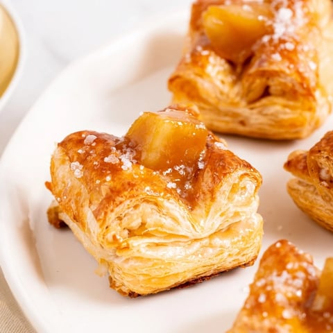 Warm caramel apple pastry bites nestled in flaky dough, perfect for a sweet treat.  