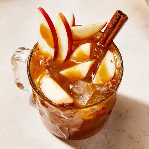 Chilled Spicy Caramel Apple Mule mocktail garnished with fresh apple slices and cinnamon.  