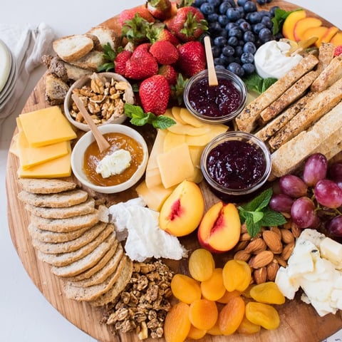 A colorful jam-infused brunch board with fresh fruits and artisan cheeses.