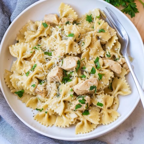 Creamy Mozzarella Garlic Butter Chicken Bowties served with fresh parsley garnishes.  