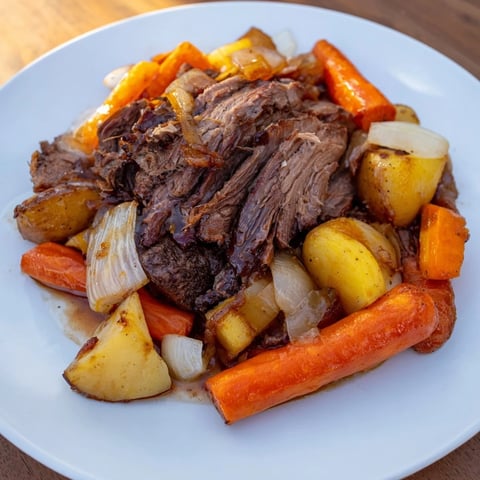 Tender Sunday Pot Roast with roasted veggies, simmering in rich broth and herbs.  