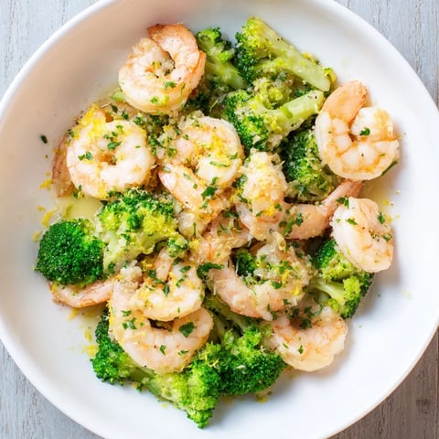 Golden-brown Lemon Butter Shrimp & Broccoli, a one-pan meal, served with fresh parsley garnish.