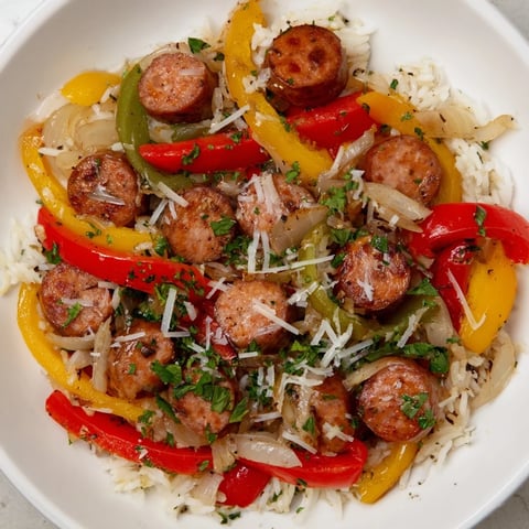 Steaming Italian Sausage & Peppers Rice Plate, loaded with colorful bell peppers and savory sausage, ready to serve!