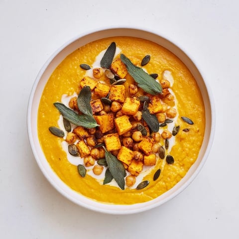 Creamy Chickpea, Pumpkin & Sage Soup, garnished with vibrant green sage leaves and toasted seeds.