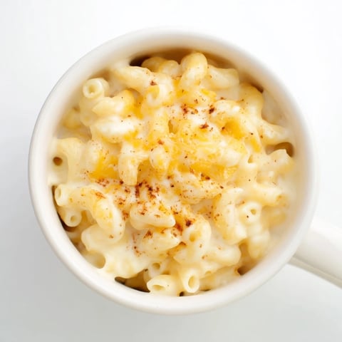 Steaming hot mug mac & cheese, a single serving of rich, creamy comfort, ready to eat.