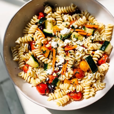 Pasta Salad with Seasonal Veggies bursts with colorful veggies tossed in a vibrant dressing.