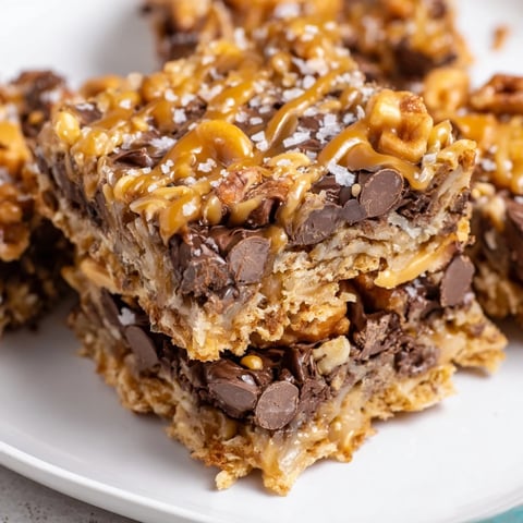 Warm, gooey 7-Layer Magic Bars with swirls of salted caramel drizzle for a delicious dessert.