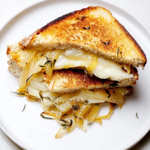 Golden, gooey French Onion Grilled Cheese, a symphony of caramelized onions and melted Gruyère.