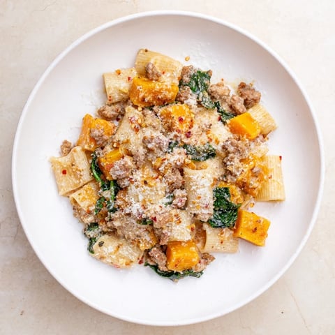 Creamy Rigatoni with Butternut Squash, a hearty pasta dish with visible sausage and Parmesan.