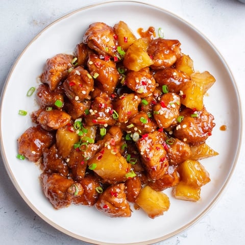Golden-brown Brown Sugar Pineapple Chicken, glistening with a sweet sauce and pineapple chunks.