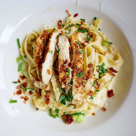 Golden-brown Southern Style Creamy Parmesan Chicken Pasta, a comforting bowl of pasta topped with sliced chicken.