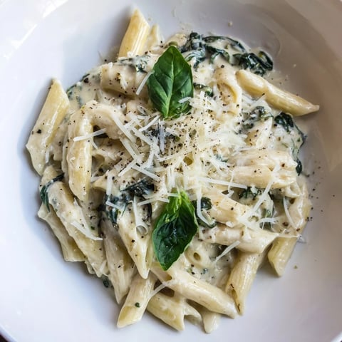 Creamy Cottage Cheese Spinach Pasta, served hot with Parmesan cheese, looks utterly delicious.