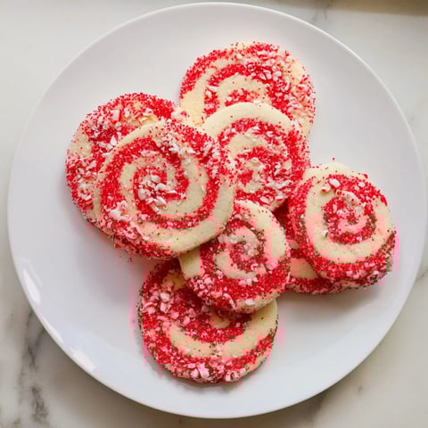 Candy Cane Swirl Cookie Platter displays festive swirled cookies with vibrant red and white peppermint candy flecks.