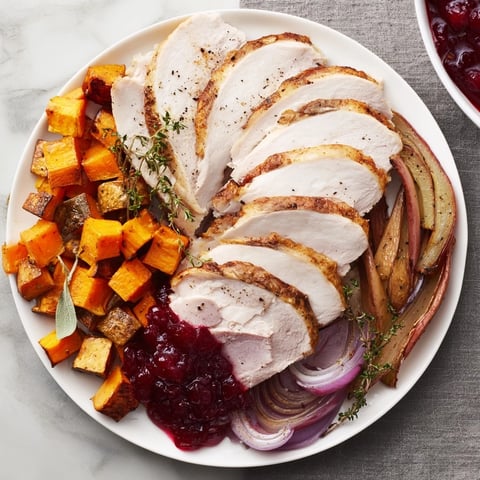 Sliced Harvest Turkey Platter, featuring juicy turkey and roasted vegetables, drizzled with cranberry sauce.