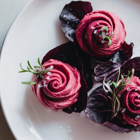 Beautiful The Velvet Rose appetizer: creamy beet hummus roses with crisp radicchio, ready to eat.