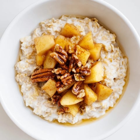 Warm apple pie oatmeal bowl, bursting with cinnamon and tender, caramelized apples, ready to enjoy.