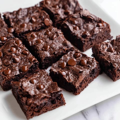 Fudgy, rich Greek Yogurt Brownies, sprinkled with chocolate chips, ready for a delicious, guilt-free dessert.