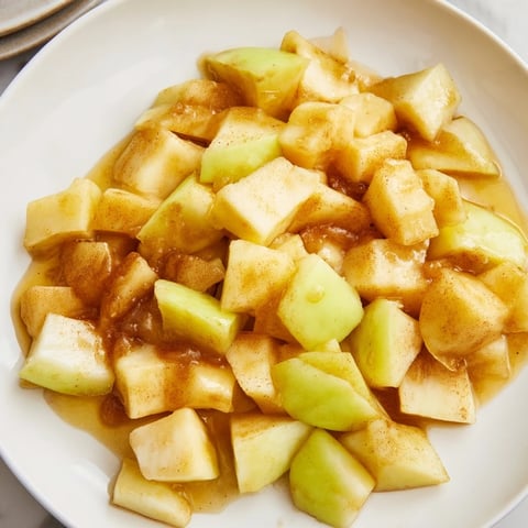 Slow cooker stewed apples bubbling gently, a warm and cinnamon-infused dessert topping.
