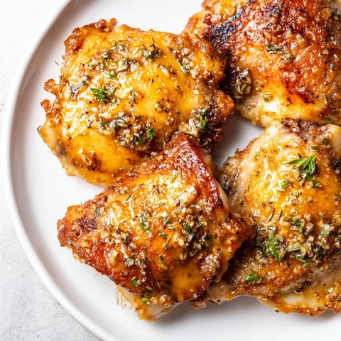 Golden-brown Garlic Butter Chicken Thighs roasted to perfection; you can almost smell the savory herbs.