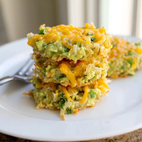 Close-up of cheesy Avocado Cheddar Rice Cake, cooked until browned, plated warmly.
