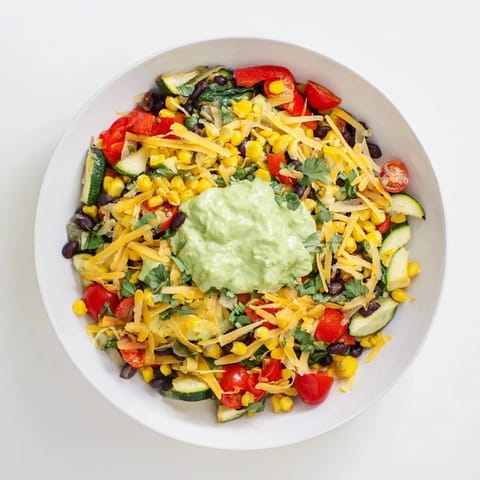 A comforting, colorful Veggie-Packed Taco Skillet with melted cheese and fresh avocado yogurt.
