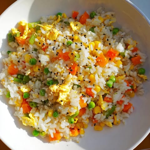 Sizzling pan of Frozen Veggie Fried Rice ready, with perfectly scrambled egg and fresh green onions.