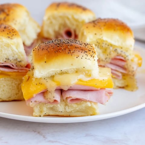 Golden-brown Baked Ham and Cheese Party Sliders, a warm, cheesy appetizer, perfect for sharing and easy to eat.