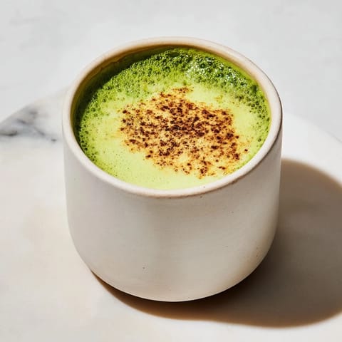 Frothy Cinnamon Maple Oat Milk Matcha Latte, garnished with cinnamon, ready to enjoy this delightful beverage.