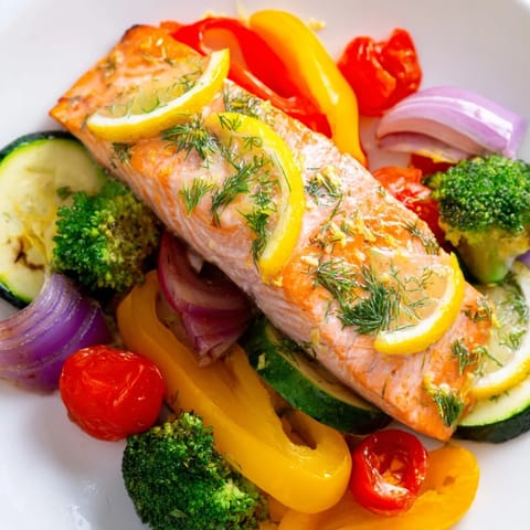Golden brown salmon sheet pan bake served with bright lemon wedges and tender roasted veggies.