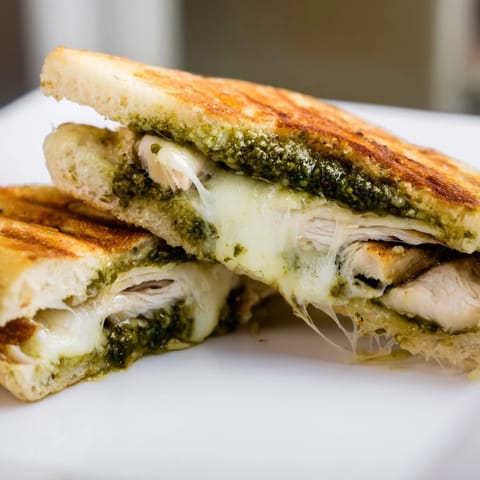 Fresh arugula and a slice of ripe tomato add color and crunch to this warm, satisfying Chicken Pesto Panini, perfect for a quick lunch or light dinner.