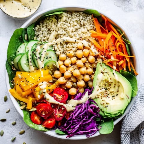 Colorful quinoa Buddha Bowl topped with crisp veggies and seeds for a wholesome lunch.