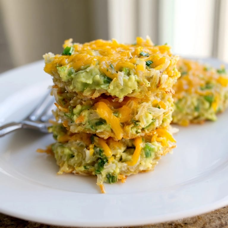 Close-up of cheesy Avocado Cheddar Rice Cake, cooked until browned, plated warmly.
