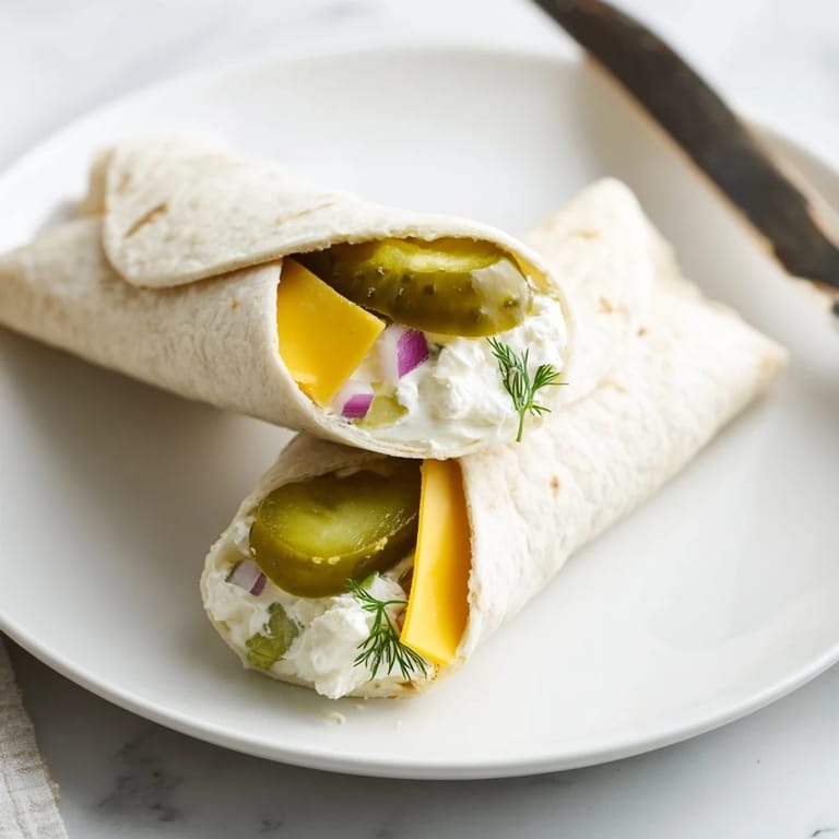 Tangy pickle-in-a-blanket bites, ideal for parties or casual gatherings.  