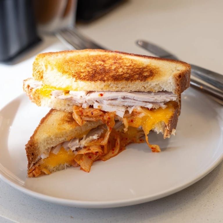 The perfectly toasted, golden sourdough Kimchi Turkey & Cheddar Grilled Cheese, oozing with melted cheese.