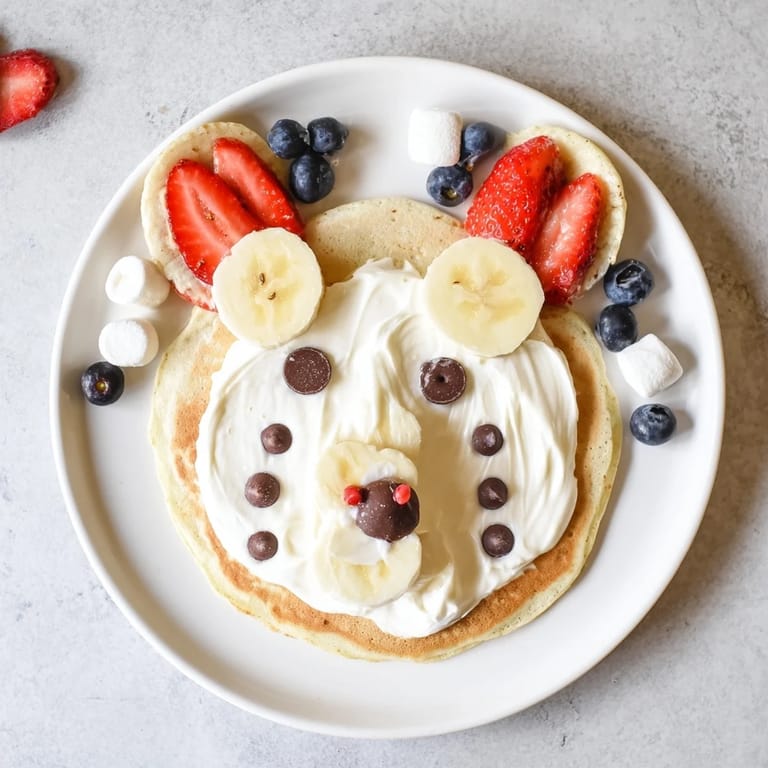A vibrant brunch board showcases adorable Polar Bear Pancakes, strawberries, and drizzled maple syrup.
